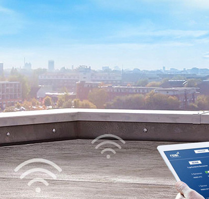Mitarbeiter mit Tablet überprüft die eigebauten Dachsensoren.