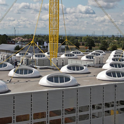 Industrieflachdach mit vielen runden Dachfenstern.