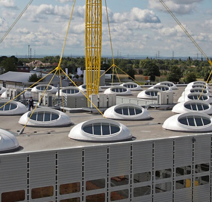 Industrieflachdach mit vielen runden Dachfenstern.