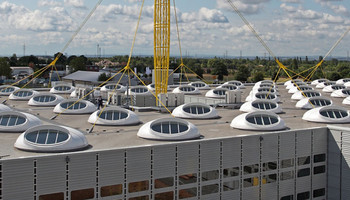Industrieflachdach mit vielen runden Dachfenstern.